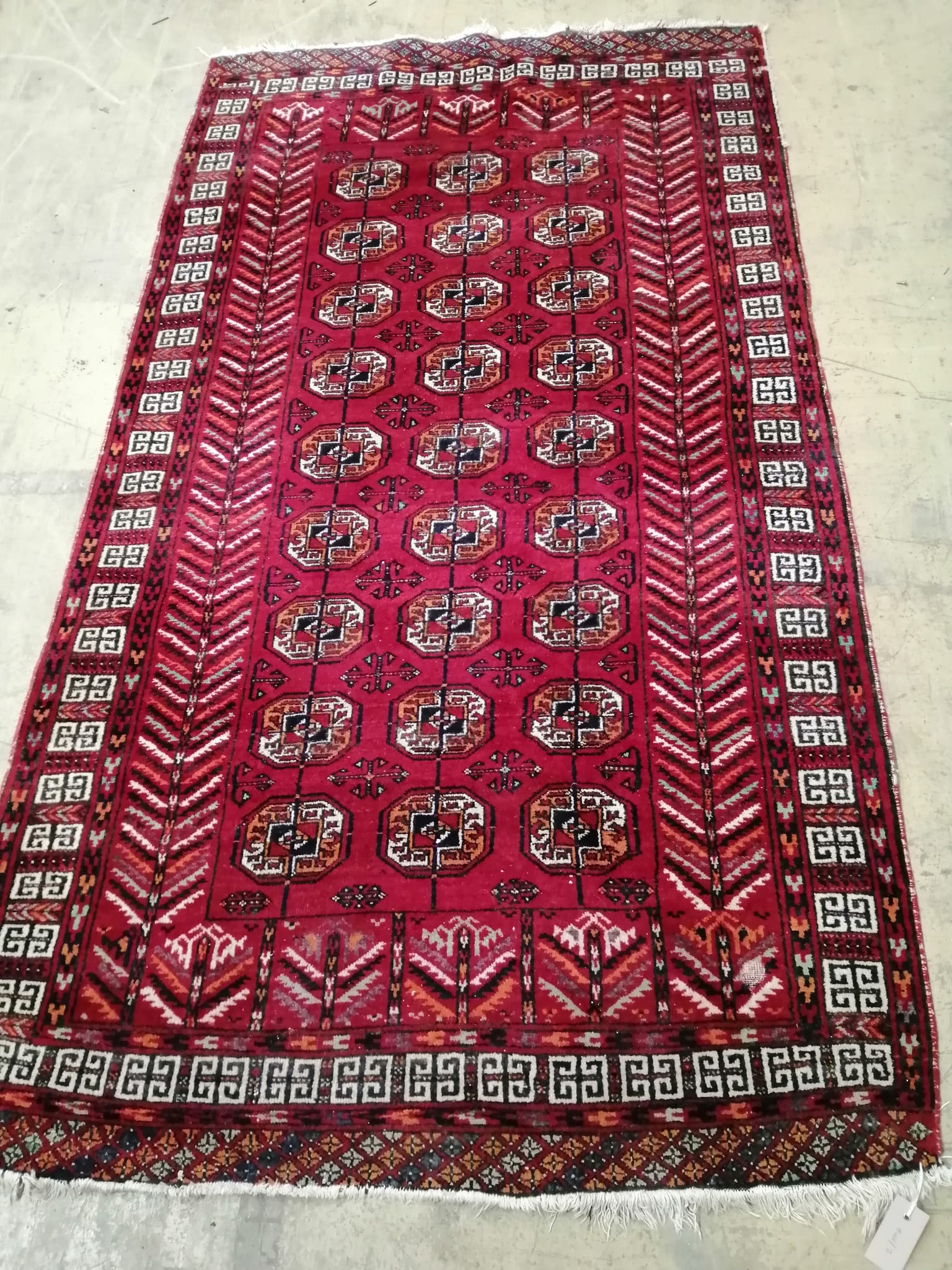 A Bokhara red ground rug, 202 x 116cm